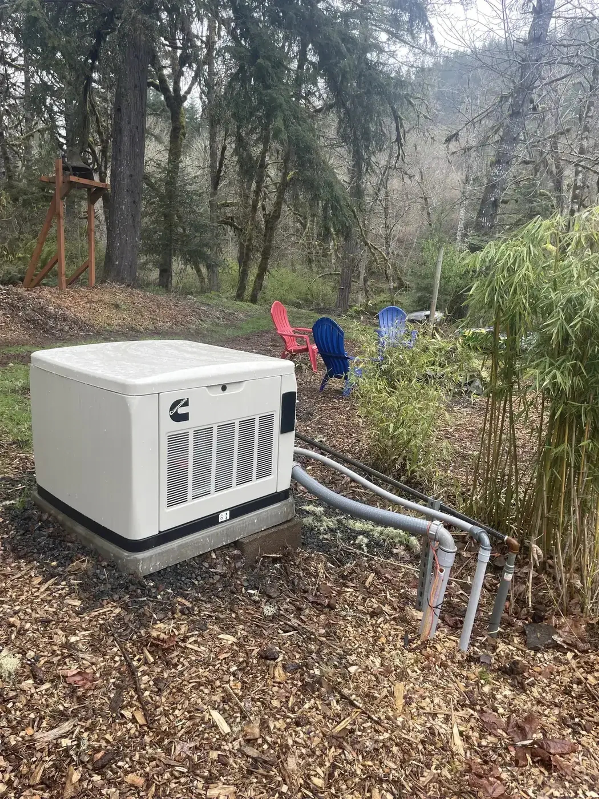 Residential standby generator installed on a wooded property